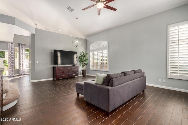 living room with dark wood-type flooring, plenty of natural light, baseboards, and visible vents