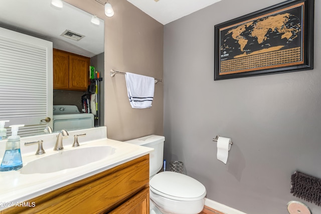 bathroom featuring washer / dryer, toilet, and vanity