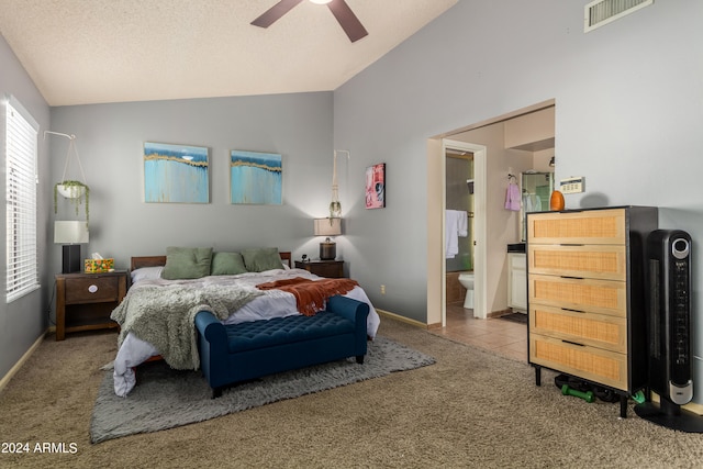 bedroom featuring lofted ceiling, light colored carpet, ensuite bathroom, a textured ceiling, and ceiling fan