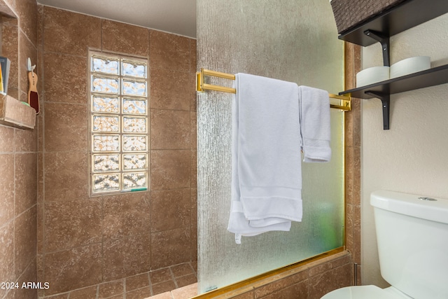 bathroom featuring toilet and tiled shower