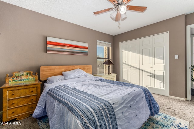 bedroom with a textured ceiling, carpet floors, a closet, and ceiling fan