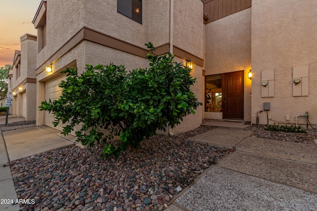 exterior entry at dusk featuring a garage