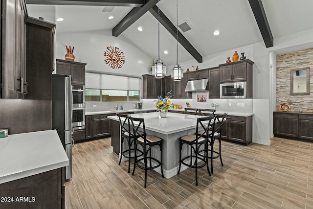 kitchen featuring a center island, decorative light fixtures, beam ceiling, and stainless steel appliances