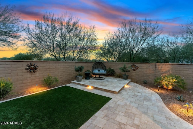 yard at dusk featuring a patio