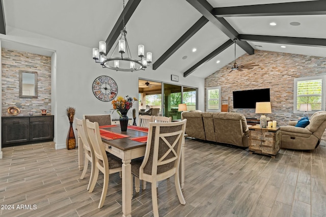 dining space with beamed ceiling, ceiling fan with notable chandelier, and high vaulted ceiling