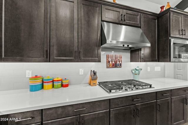 kitchen featuring dark brown cabinets, backsplash, and stainless steel appliances