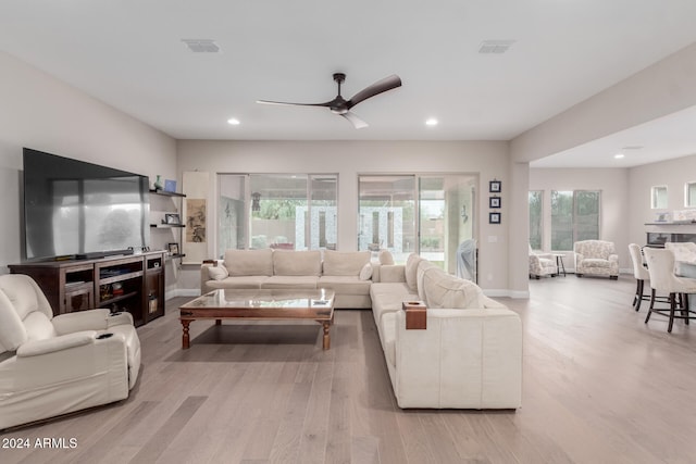 living room featuring ceiling fan and light hardwood / wood-style flooring