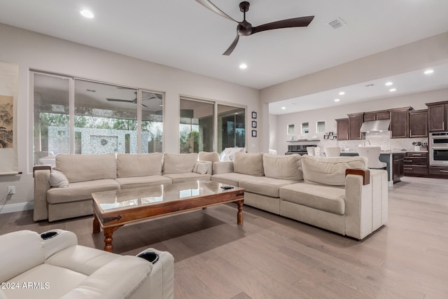 living room featuring light hardwood / wood-style flooring and ceiling fan