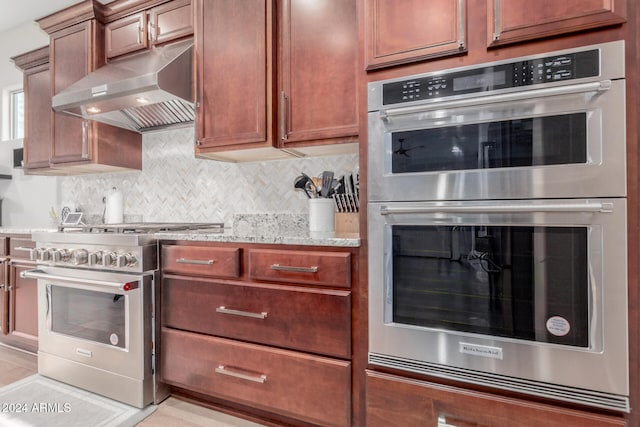 kitchen with tasteful backsplash, light stone countertops, and stainless steel appliances