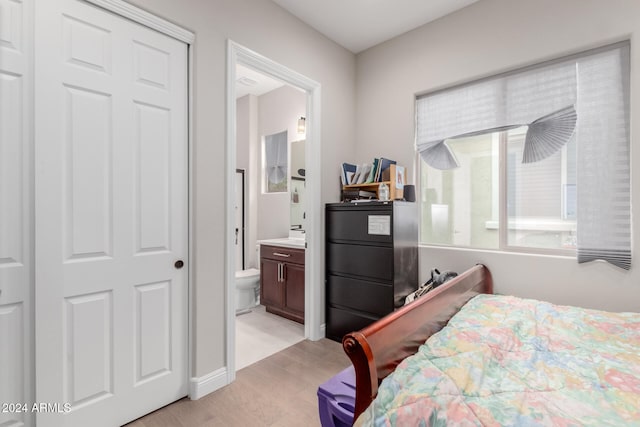 bedroom featuring light wood-type flooring and connected bathroom