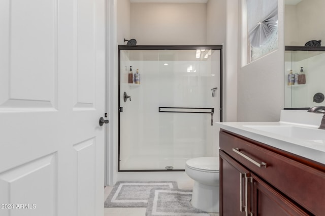 bathroom featuring vanity, toilet, and an enclosed shower