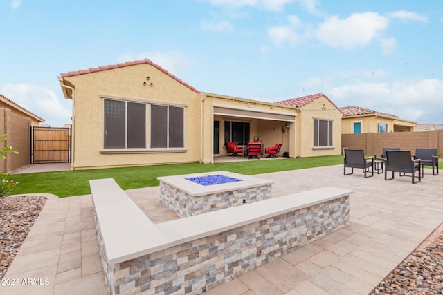 back of property featuring an outdoor living space with a fire pit and a patio area