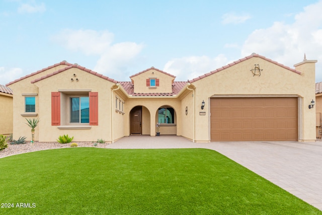 mediterranean / spanish home with a garage and a front yard