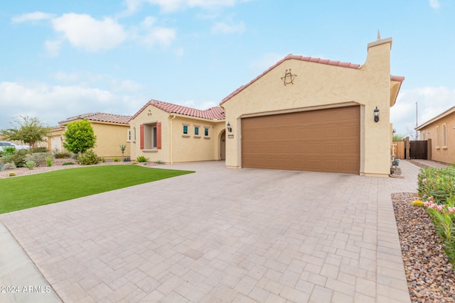 mediterranean / spanish home with a front lawn and a garage