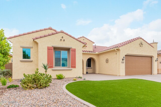 mediterranean / spanish house featuring a front yard and a garage