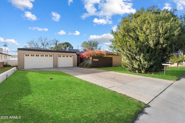 ranch-style home featuring an attached garage, concrete driveway, and a front yard