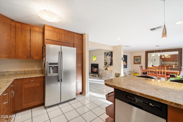 kitchen with light tile patterned floors, visible vents, appliances with stainless steel finishes, and brown cabinetry