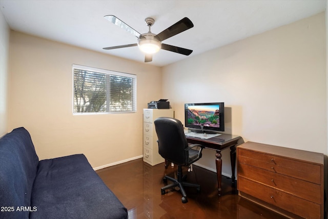 office space with a ceiling fan and baseboards