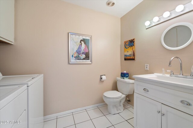 bathroom with toilet, vanity, separate washer and dryer, baseboards, and tile patterned floors