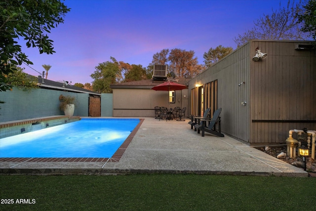 pool at dusk featuring a fenced in pool, a patio area, and central AC unit