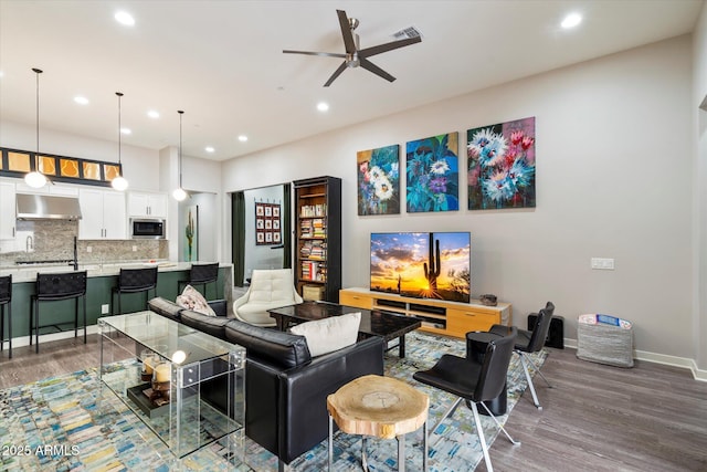 living room featuring recessed lighting, wood finished floors, baseboards, and ceiling fan
