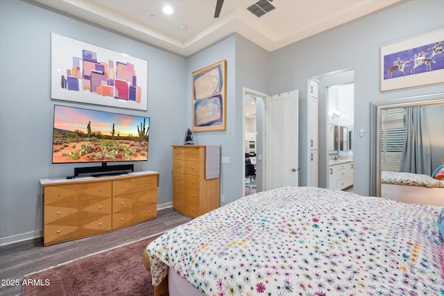 bedroom featuring connected bathroom, visible vents, baseboards, dark wood-style floors, and recessed lighting