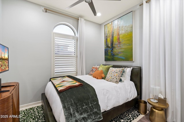 bedroom with wood finished floors, a ceiling fan, and baseboards