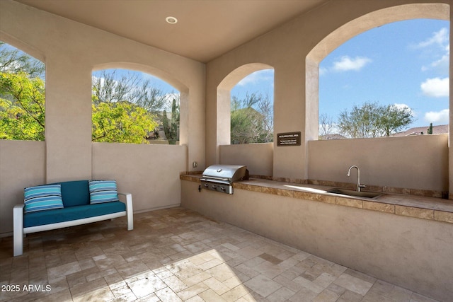 view of patio featuring an outdoor kitchen, a sink, and area for grilling