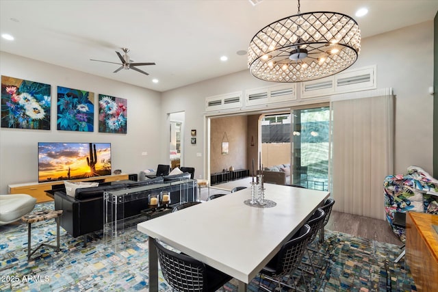 dining space with recessed lighting, wood finished floors, and ceiling fan with notable chandelier