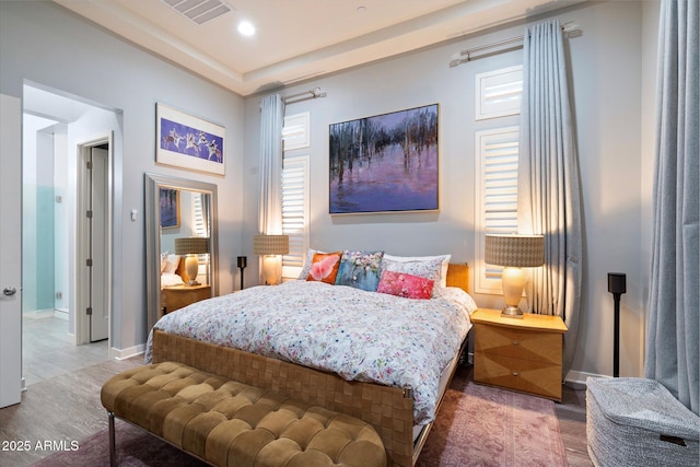 bedroom featuring baseboards, wood finished floors, and visible vents