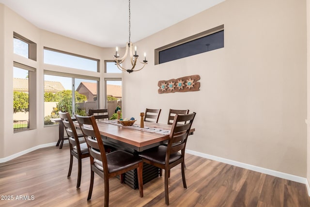 dining area with hardwood / wood-style flooring and a notable chandelier