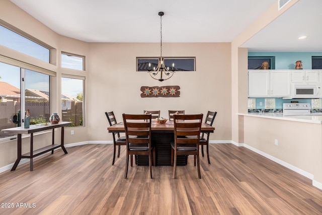 dining space featuring a chandelier and light wood-type flooring