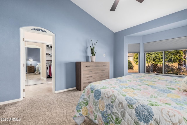 carpeted bedroom featuring lofted ceiling, a spacious closet, a closet, and ceiling fan