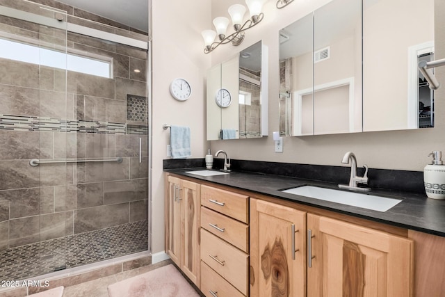 bathroom featuring vanity, an inviting chandelier, and a tile shower