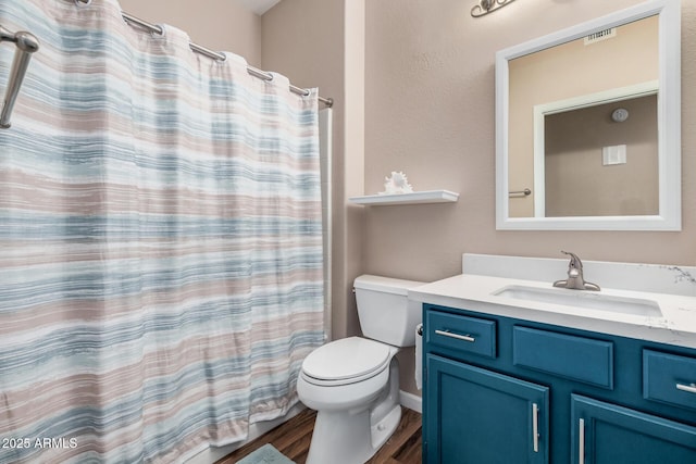 bathroom featuring vanity, hardwood / wood-style floors, curtained shower, and toilet