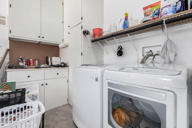 laundry area featuring cabinets and washer and clothes dryer