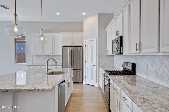 kitchen featuring white cabinetry, sink, an island with sink, and appliances with stainless steel finishes