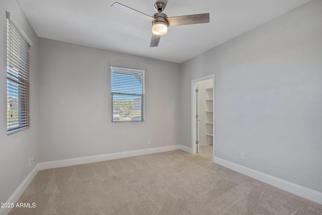 carpeted spare room featuring ceiling fan