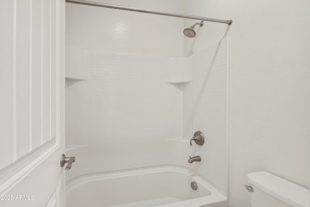 bathroom featuring toilet and tiled shower / bath combo