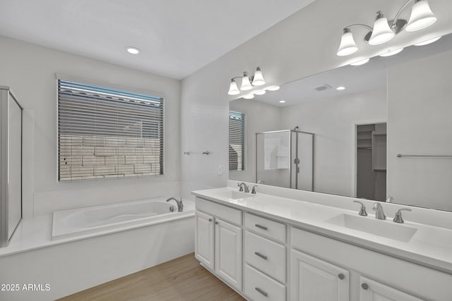 bathroom featuring vanity, hardwood / wood-style floors, and separate shower and tub