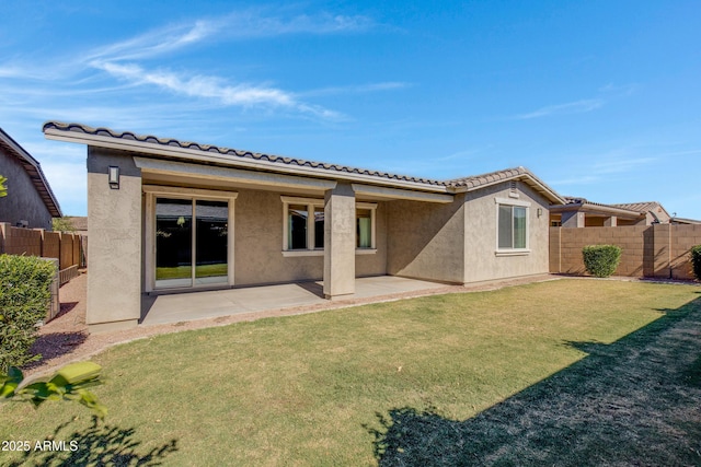 rear view of property featuring a patio area and a lawn