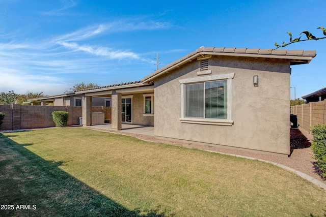 rear view of property with a yard and a patio area