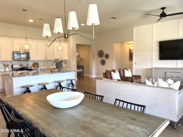 dining room with dark wood-type flooring and ceiling fan