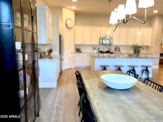 dining space with a notable chandelier and light hardwood / wood-style flooring