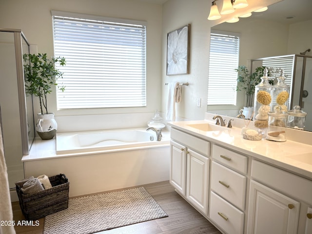 bathroom featuring plenty of natural light, plus walk in shower, hardwood / wood-style floors, and vanity