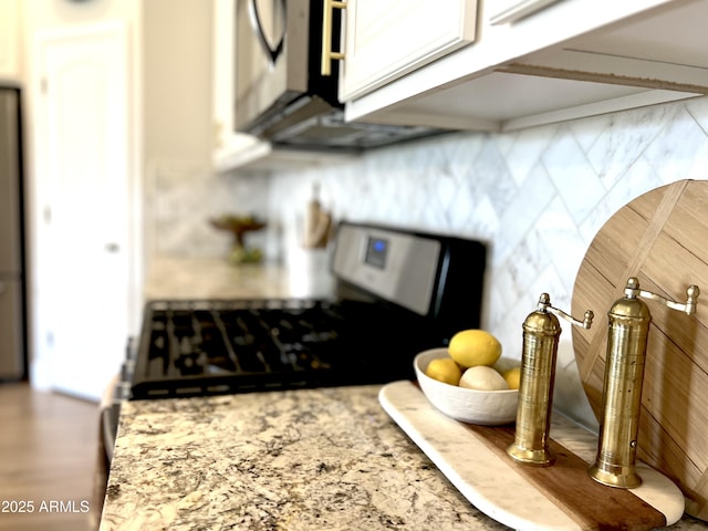 room details featuring white cabinetry and light stone counters