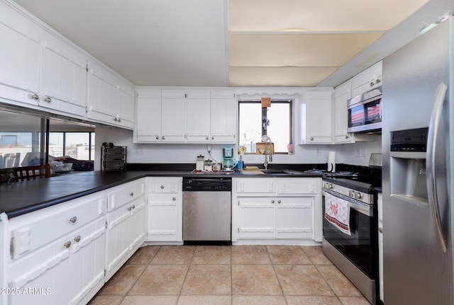 kitchen featuring white cabinetry, appliances with stainless steel finishes, light tile patterned flooring, and sink