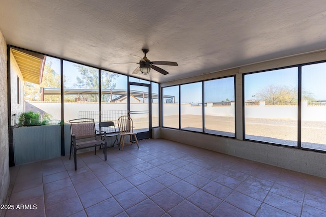 unfurnished sunroom featuring ceiling fan