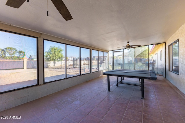 unfurnished sunroom with ceiling fan and a healthy amount of sunlight