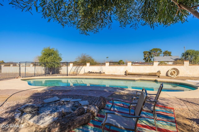 view of swimming pool featuring an outdoor fire pit